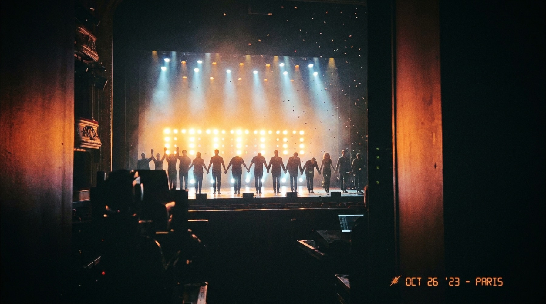 Une troupe saluant à contre-jour, silhouettes devant un mur de lumière